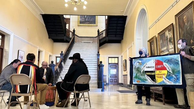 Passamaquoddy Tribal
Representative Aaron Dana (facing viewer), then clockwise Wambli
Martinez, Amuwes Dana and Nicholas Paul drum in the Hall of Flags
for the 2023 Wabanaki Alliance Lobby Day. Barbara and Terry Baker
hold the banner.